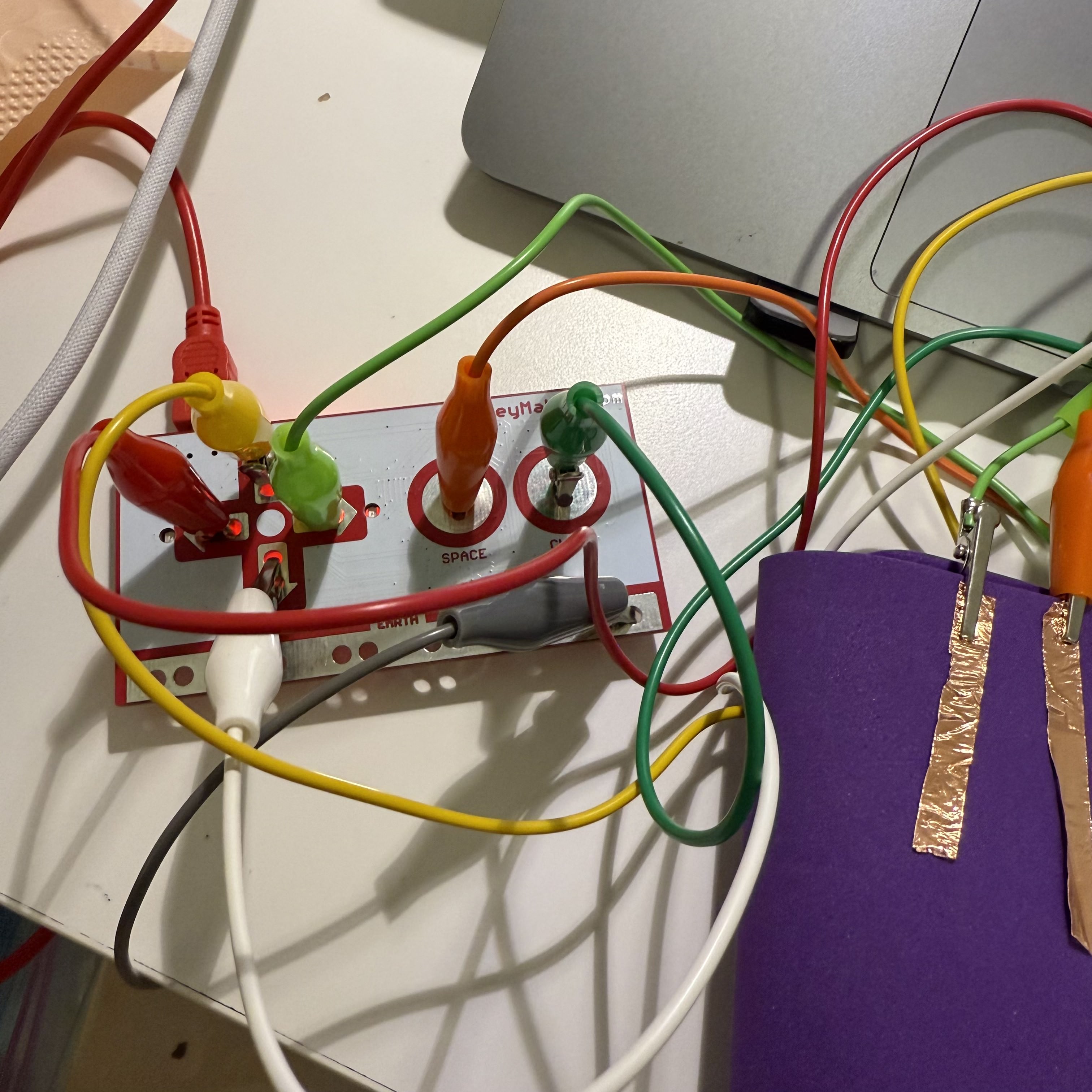 In my experiment, I use a Makey Makey board connected to various wires. Each wire is attached to a different button on the board, allowing me to control specific actions on my computer through these simple connections.